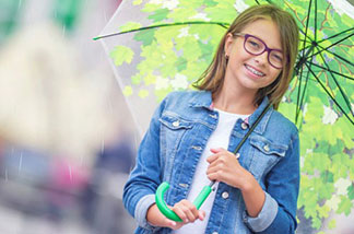 Teen age girl with glasses smiling.